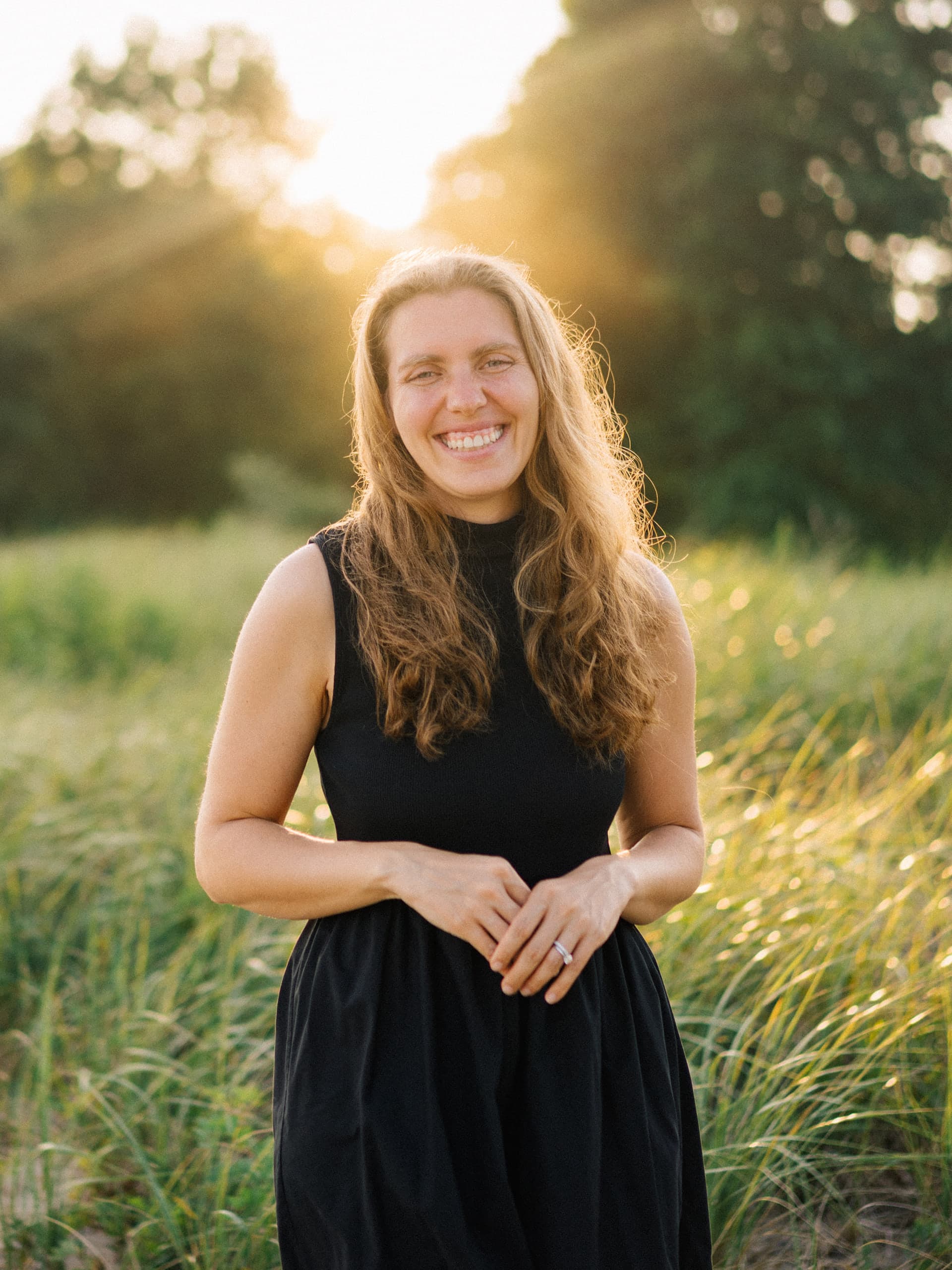 Beth Zink Linke smiling in a field at golden hour