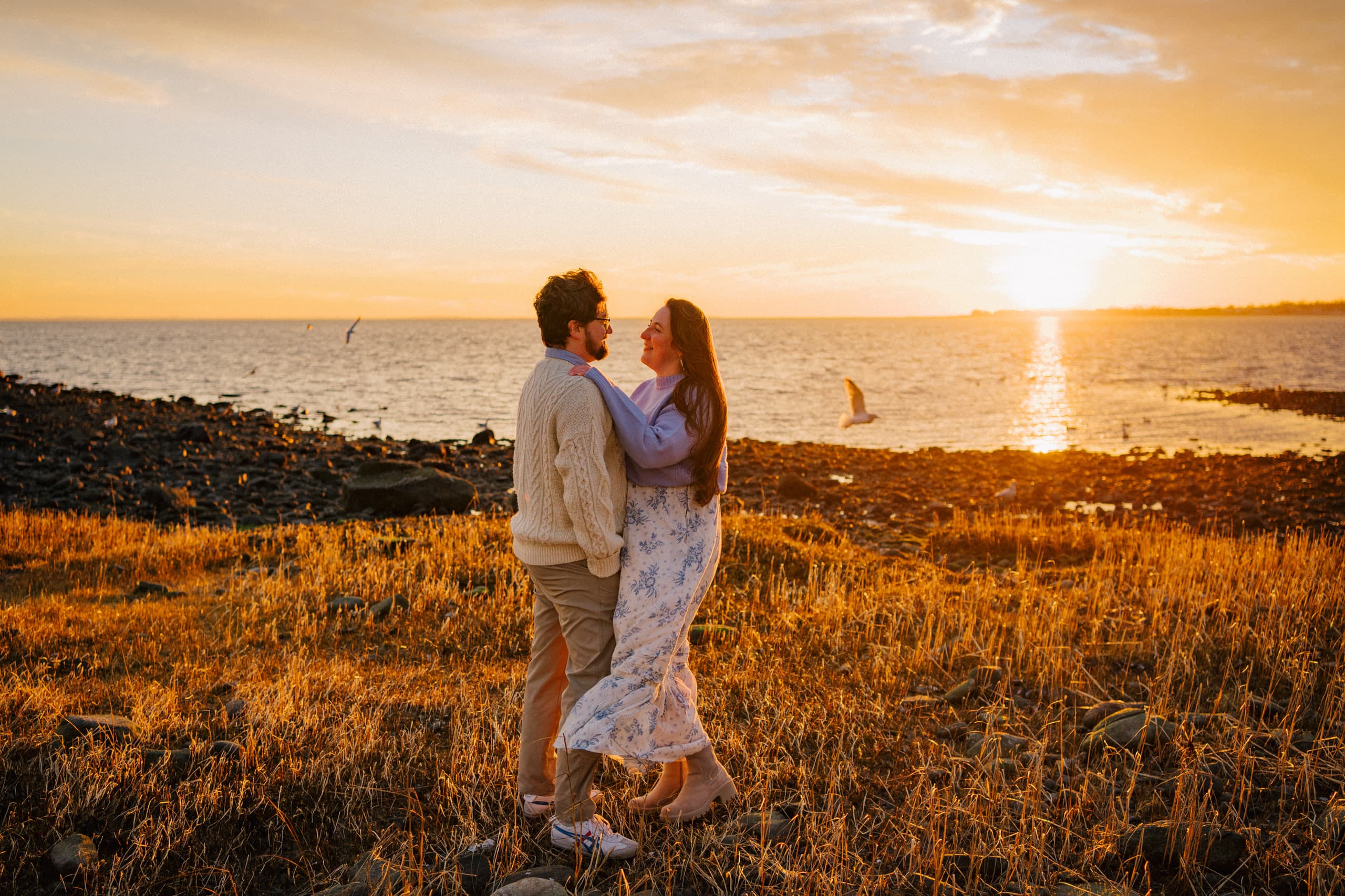 Couple embracing at sunset by the water