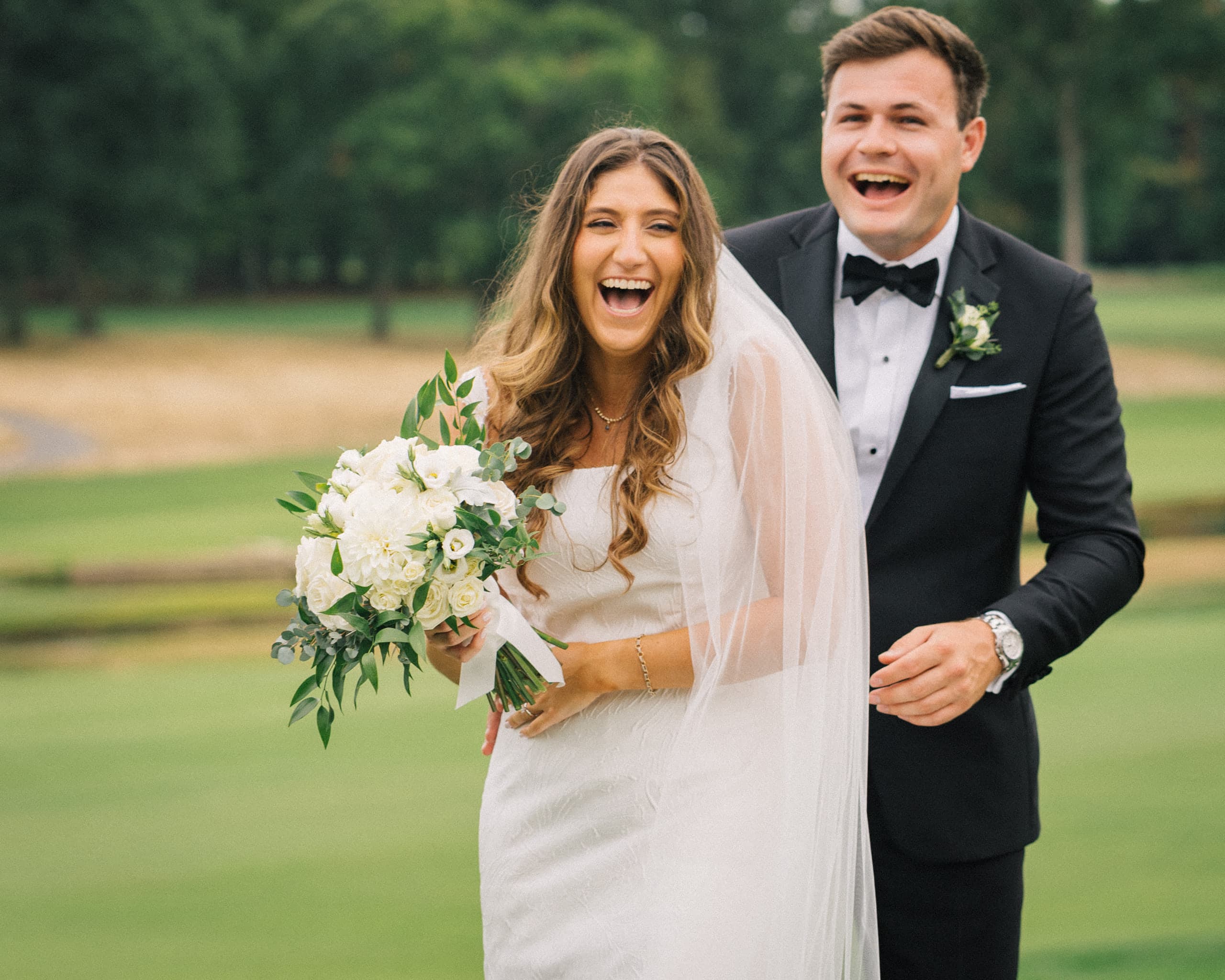 Bride and groom laughing together outdoors