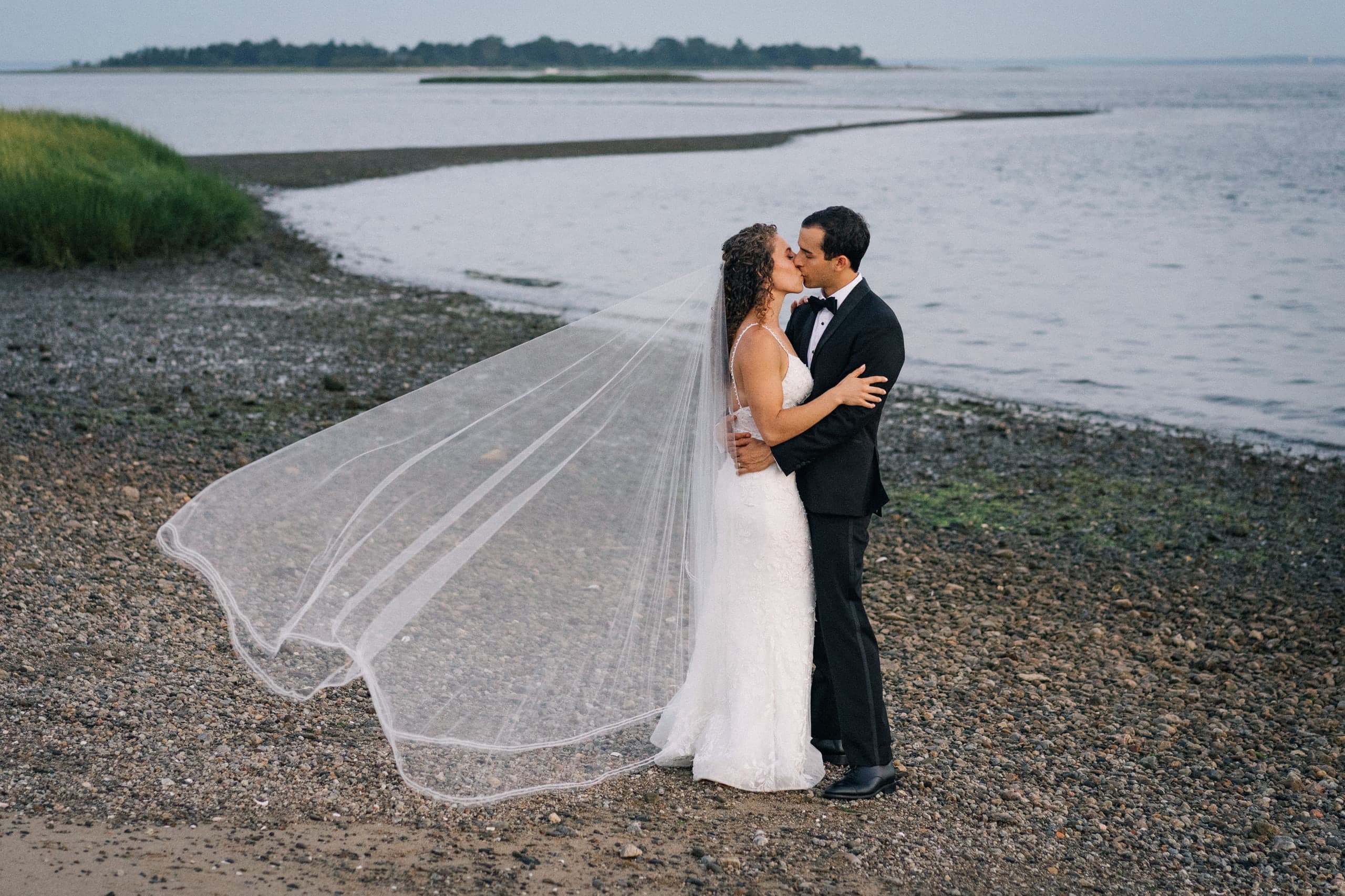 Bride's veil blowing in the wind on the beach
