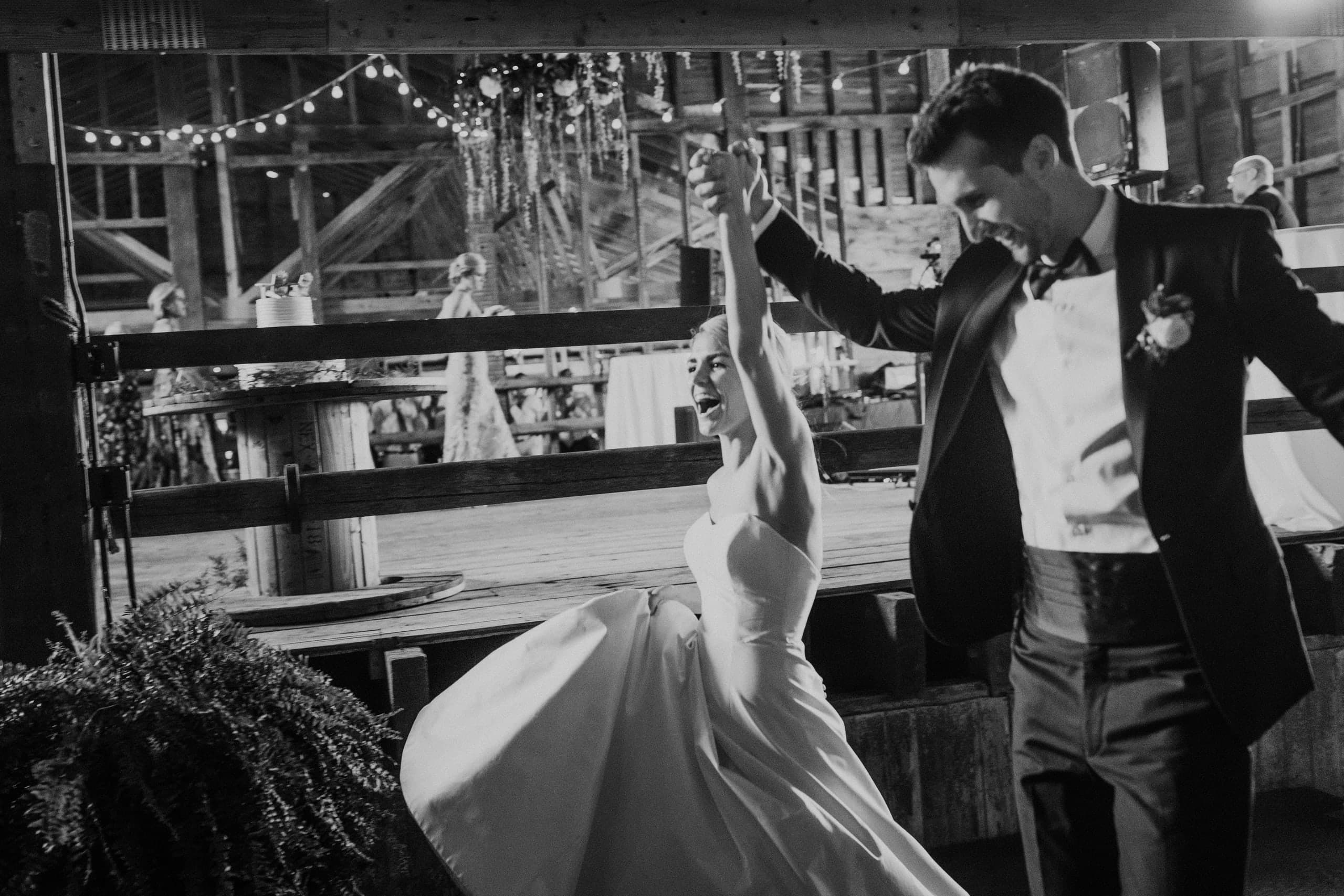 Black and white photo of the couple dancing in a barn reception