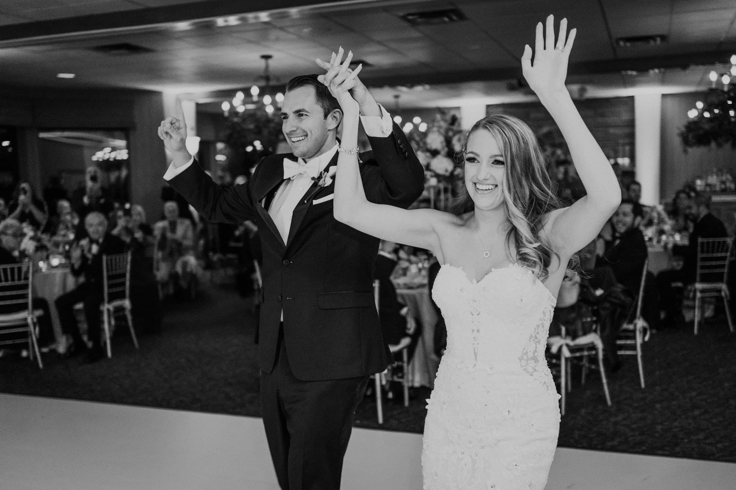 The newlyweds make their entrance, arms raised, black and white