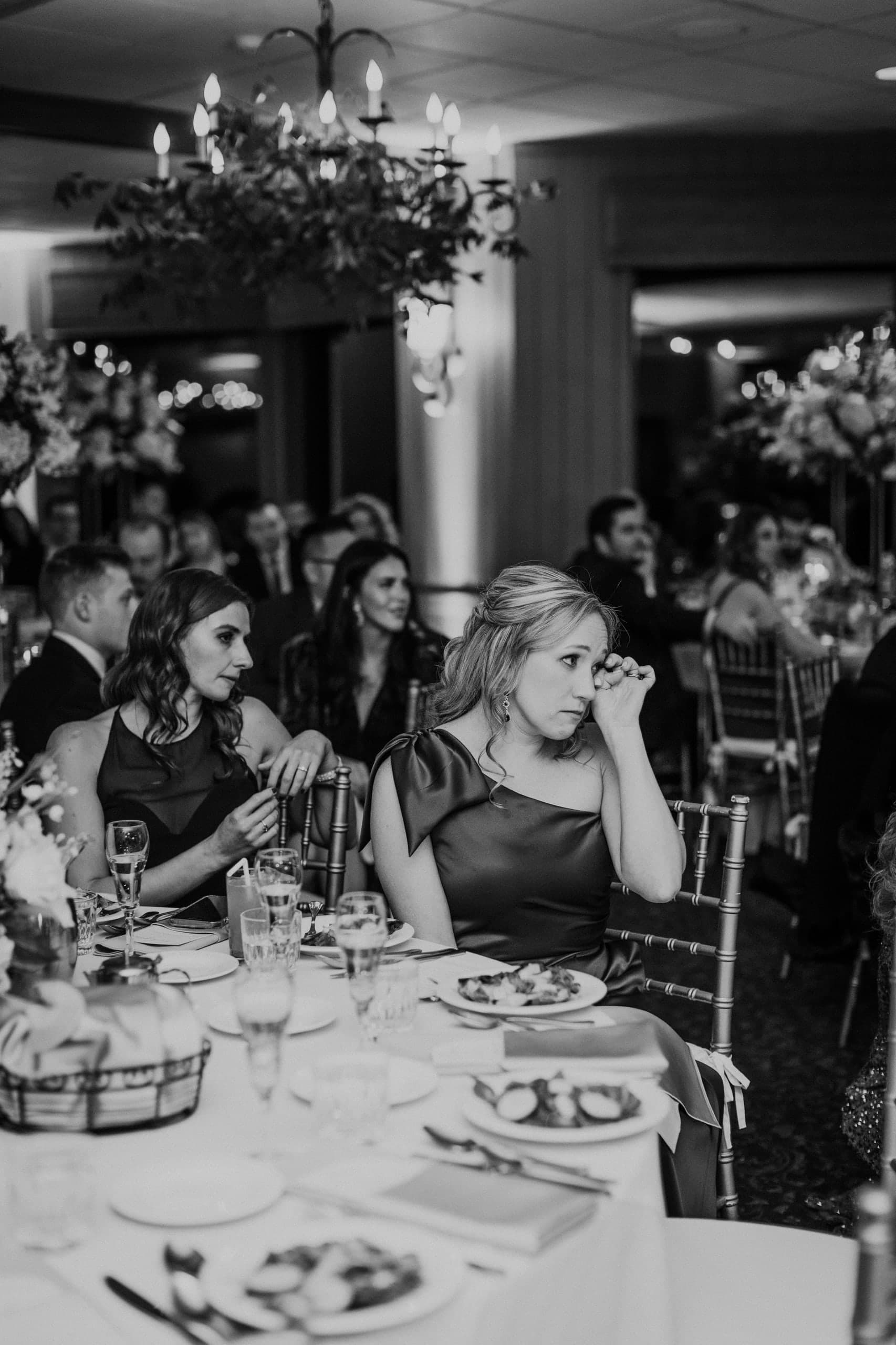 A guest wipes away a tear during the toasts, black and white
