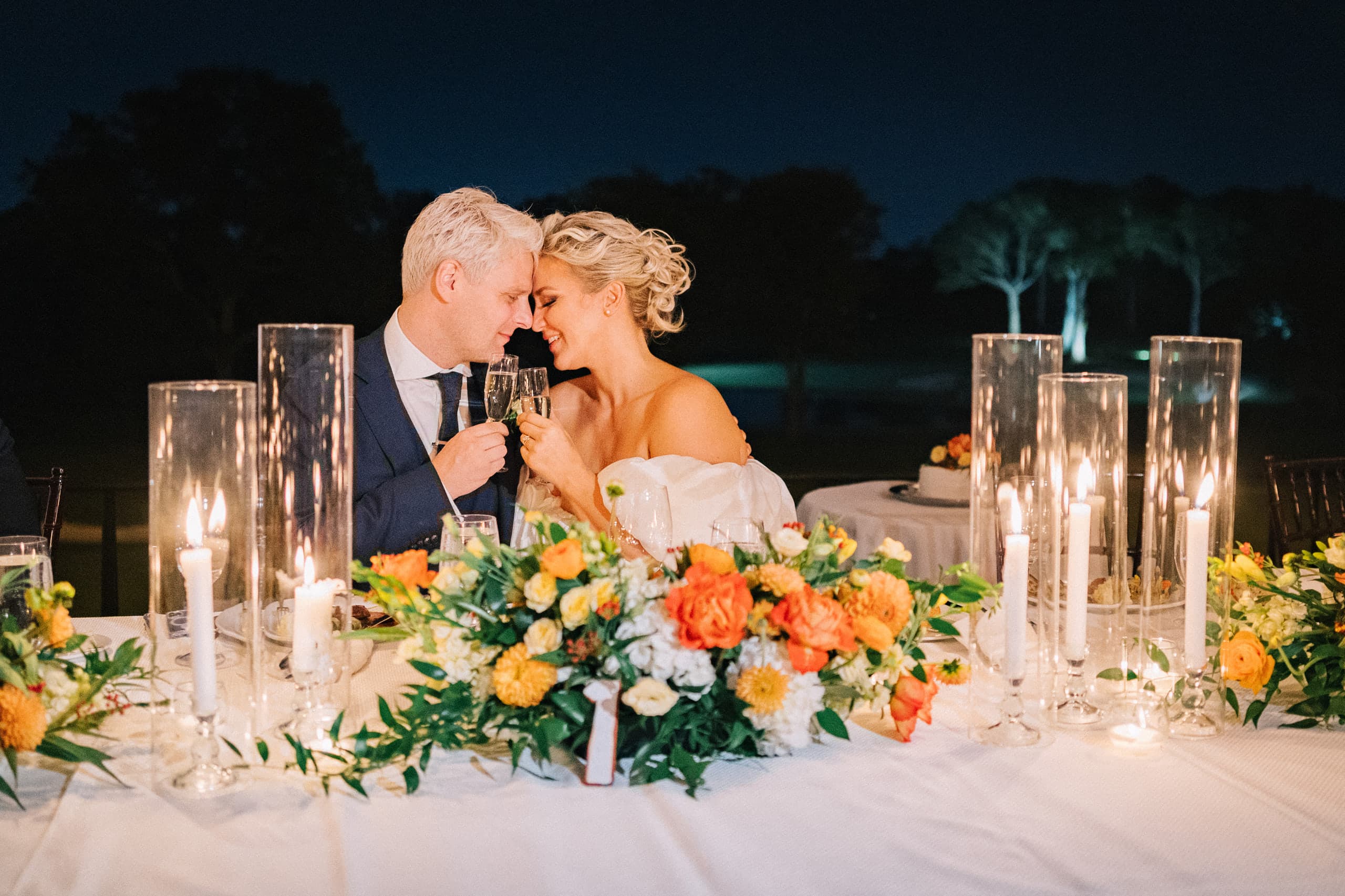 Foreheads together over champagne, candles burning down the night table