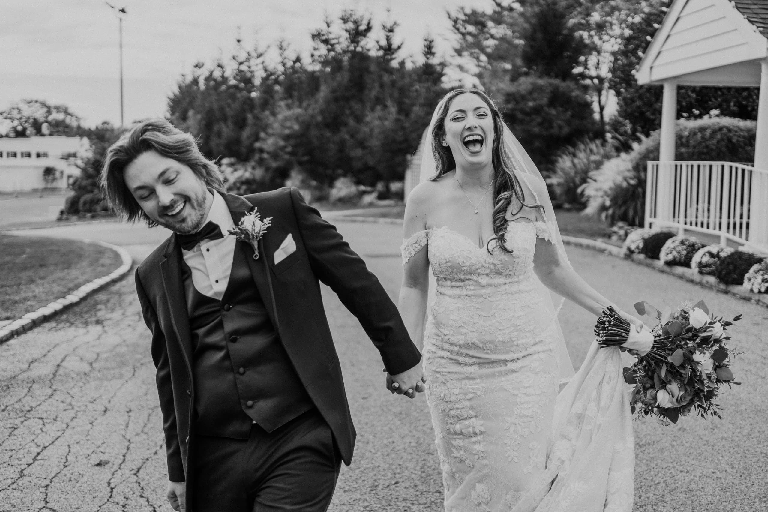 Running hand in hand down the drive, mid-laugh, in black and white