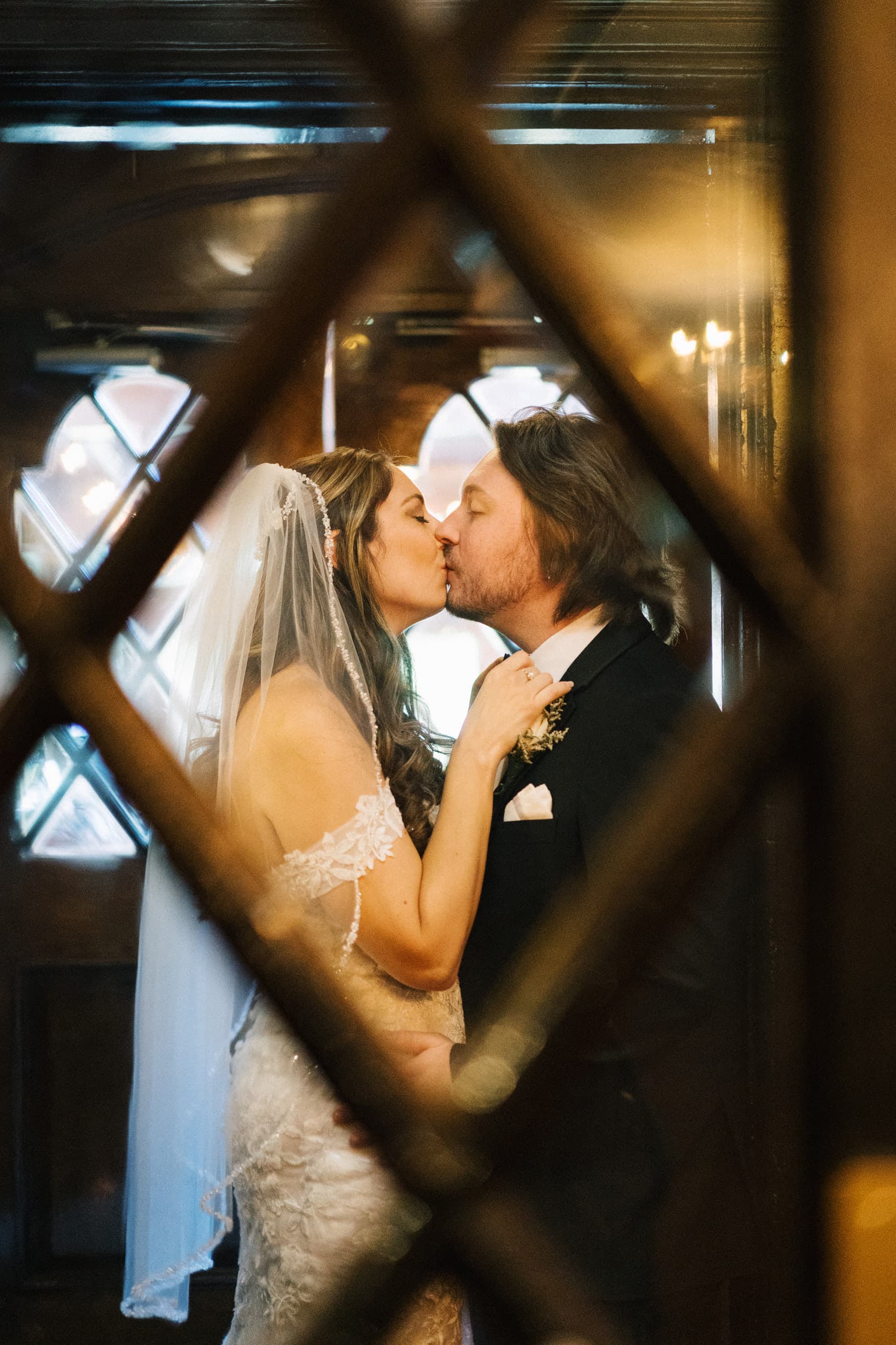 A kiss glimpsed through the diamond panes of a leaded window